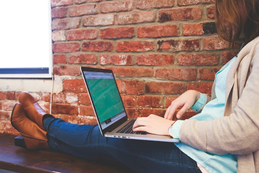 Young professional working on laptop logo